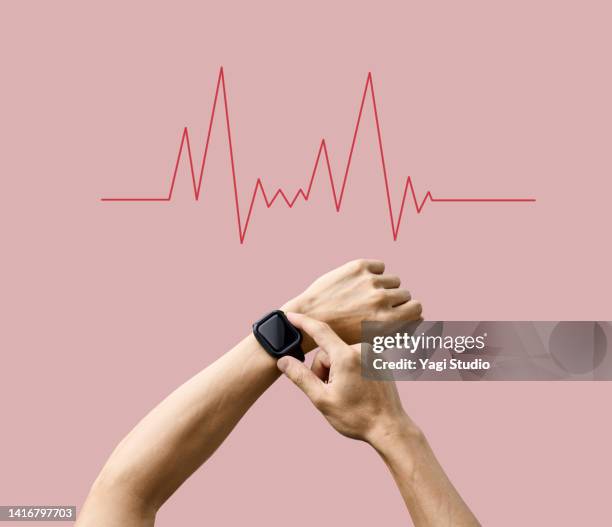 close-up of a man's arm measuring his heart rate with a smartwatch - wearable stock-fotos und bilder