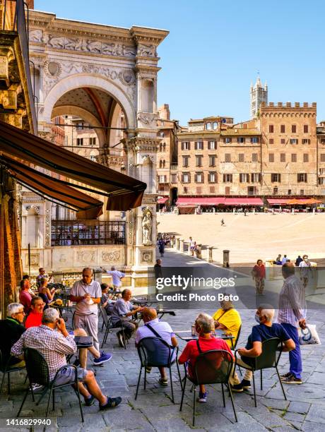 a scene of italian daily life in a sidewalk café in piazza del campo in the medieval heart of siena in tuscany - praça do campo imagens e fotografias de stock