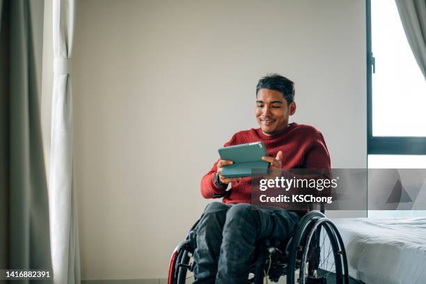 disability wheelchair disabled man handicap sitting handicapped health young wheel care invalid tablet online communication cal video healthcare - paralysis stock pictures, royalty-free photos & images