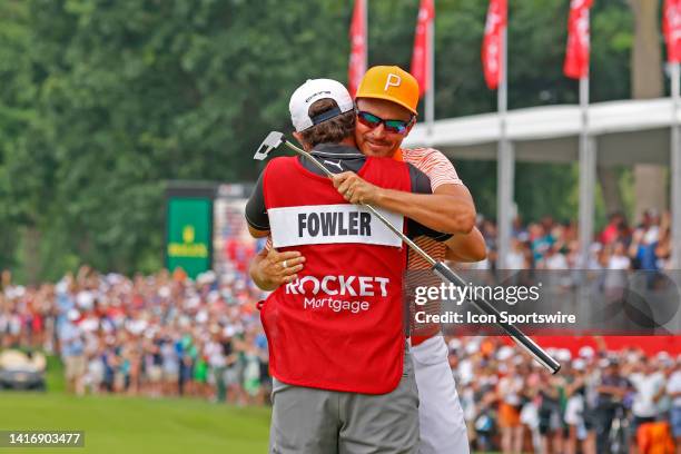 Golfer Rickie Fowler gets a hug from his caddie Ricky Romano on the 18th green after winning in a 3 way playoff on July 2 during the final round of...