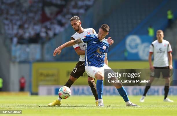 Leart Paqarada of FC St. Pauli is challenged by Ryan Malone of FC Hansa Rostock during the Second Bundesliga match between F.C. Hansa Rostock and FC...