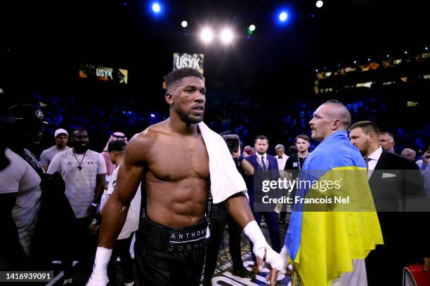 Oleksandr Usyk holds their belts as Anthony Joshua looks on after their World Heavyweight Championship fight during the Rage on the Red Sea...