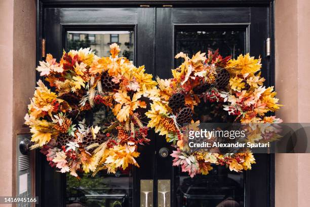 wreath made of autumn leaves on the townhouse door, close-up - autumn wreath stock pictures, royalty-free photos & images