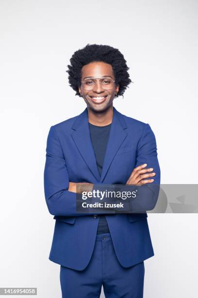 confident businessman with arms crossed - blauw pak stockfoto's en -beelden