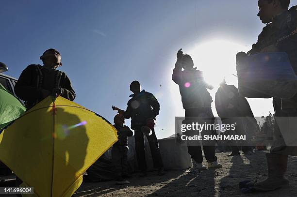 With Afghanistan-social-leisure-NewYear by Joris Fioriti In this picture taken on March 21, 2012 Afghan boys fly kites on a hilltop overlooking...