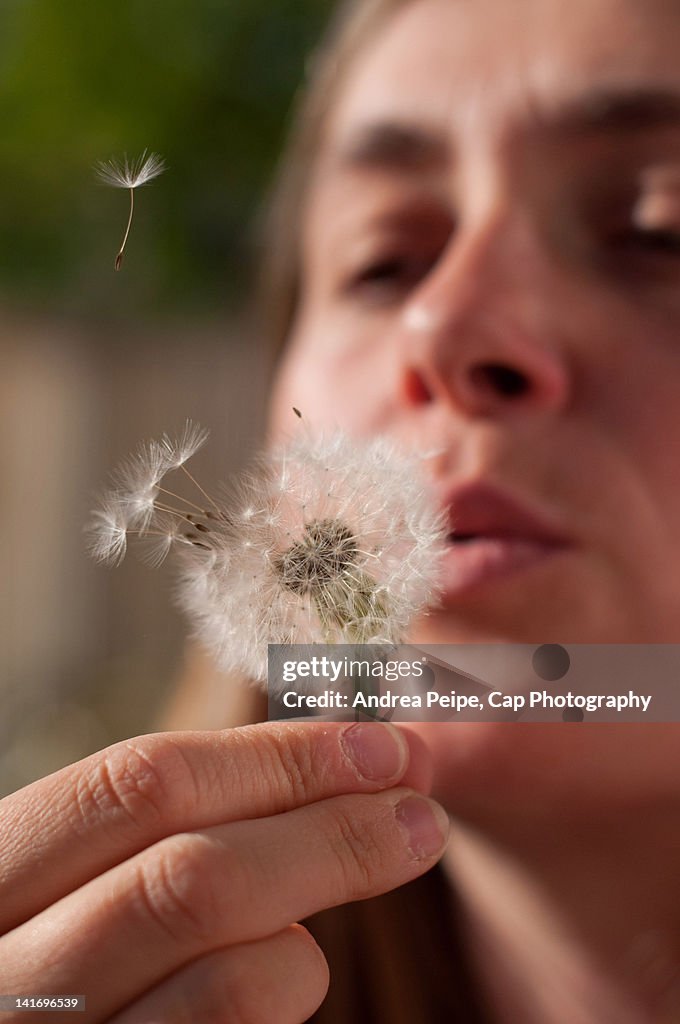 Woman with dandelion in hand