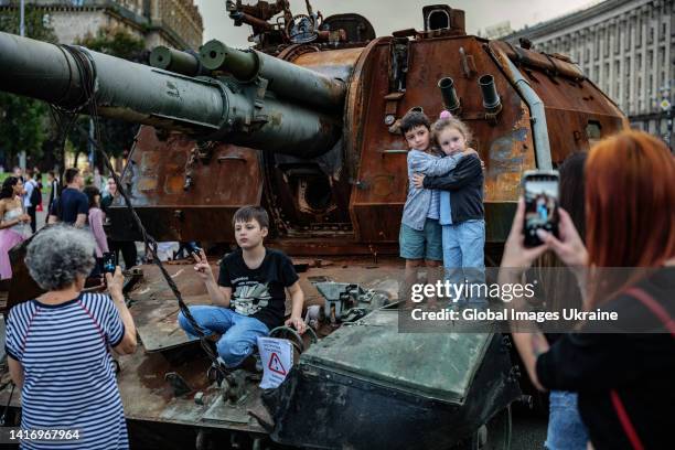 Women photograph children on the remains of Russian tank exhibited on August 20, 2022 in Kyiv, Ukraine. On August 24, Ukraine celebrates its 1991...