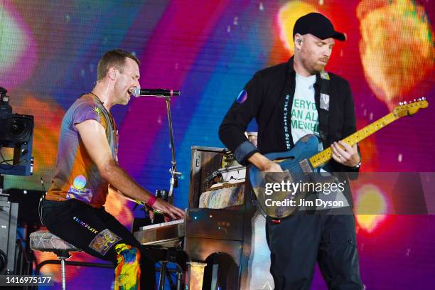 Chris Martin of Coldplay and Jonny Buckland perform on stage at Wembley Stadium during the 'Music of the Spheres' World Tour on August 12, 2022 in...