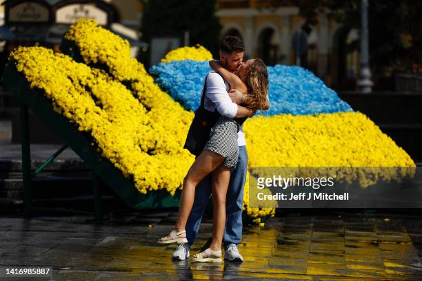 People stand beside flowers ahead of Ukraine Day of the National Flag on August 22, 2022 in Lviv, Ukraine. August 24 marks six months since Russia...