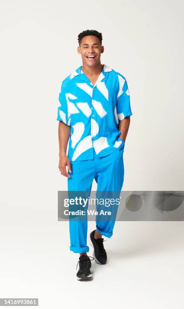 fashionable man walking with hands in pocket - mann fashion stock-fotos und bilder