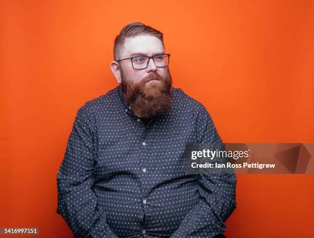 bearded man on orange background making funny faces - portrait orange background stock pictures, royalty-free photos & images