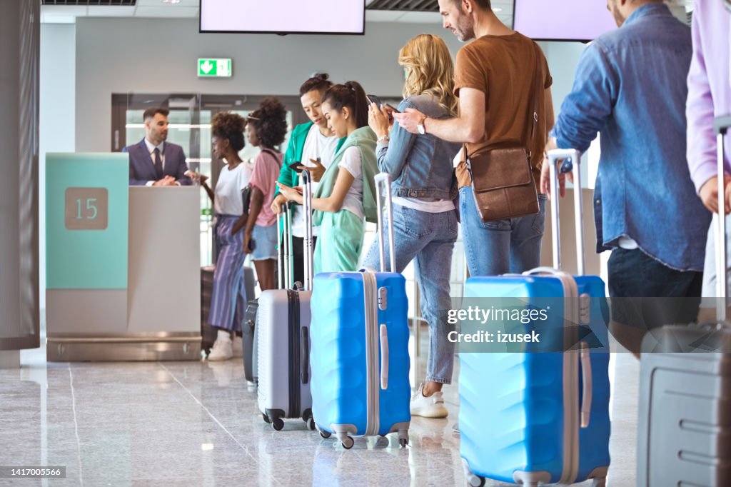 Passagiere mit Gepäck warten in der Schlange