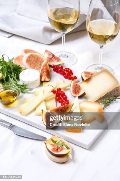 cheese board set of italian and french cheeses with figs and red currants. parmesan, pecorino, goat cheese on a marble board. a cheese plate in the restaurant for white wine and aperitif - cheese and champagne stock pictures, royalty-free photos & images