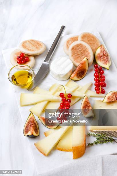 cheese board set of italian and french cheeses with figs and red currants. parmesan, pecorino, goat cheese on a marble board. a cheese plate in the restaurant for white wine and aperitif - wine white color stock pictures, royalty-free photos & images