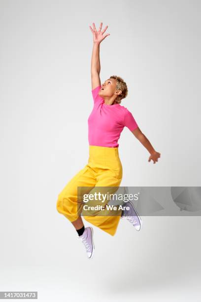 energetic woman jumping - 手を伸ばす 女性 ストックフォトと画像