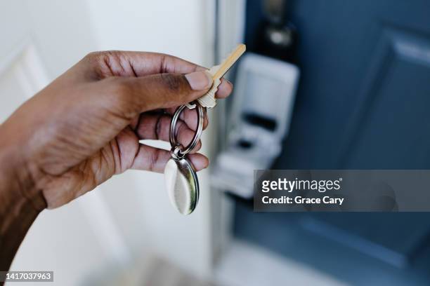 real estate agent accesses house key from lockbox hanging on house's front door handle - house viewing stock pictures, royalty-free photos & images