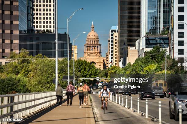 fußgänger und verkehr fahren die congress avenue am texas state capitol in austin entlang - business south america stock-fotos und bilder