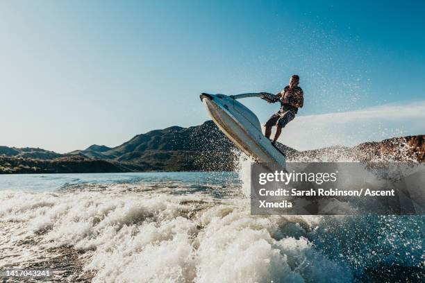 jet skier gets air off of a wave - sprung wassersport stock-fotos und bilder