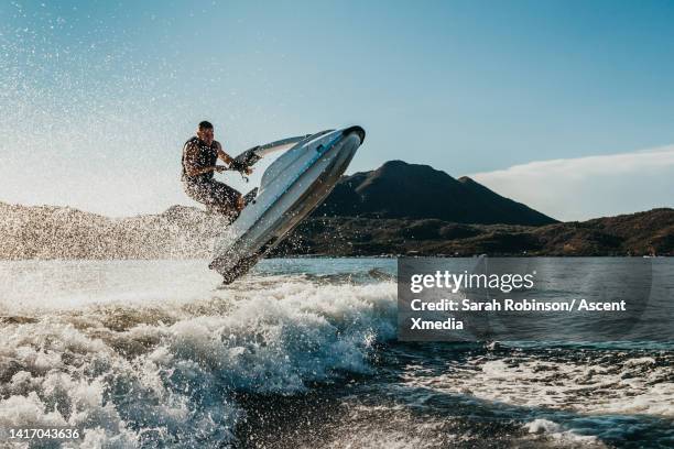 jet skier gets air off of a wave - sprung-wassersport stock-fotos und bilder