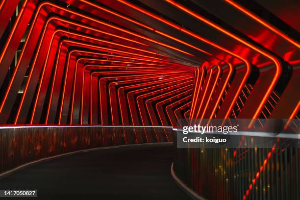 footbridge with red neon effect - city lights stock-fotos und bilder