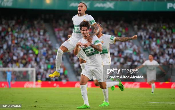 Alex Collado of Elche celebrates with teammates after scoring their side's first goal during the LaLiga Santander match between Elche CF and UD...