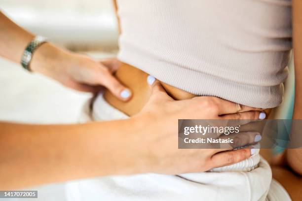 young woman at physical therapist having backpain - lumbar vertebra stock pictures, royalty-free photos & images