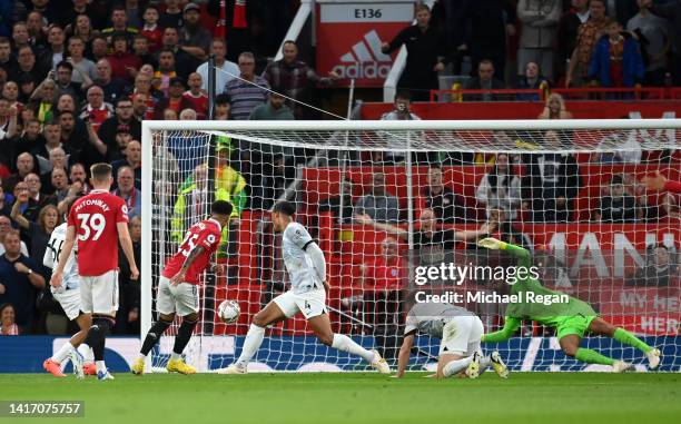 Jadon Sancho of Manchester United scores their side's first goal past Alisson Becker of Liverpool during the Premier League match between Manchester...