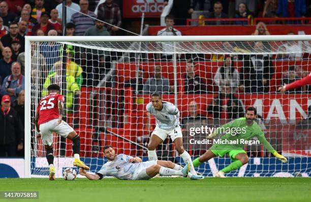 Jadon Sancho of Manchester United is challenged by James Milner of Liverpool before scoring their side's first goal during the Premier League match...