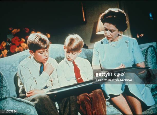 Queen Elizabeth II looking at a photograph album with her sons Prince Andrew and Prince Edward, December 1971. Footage of this scene was used in the...