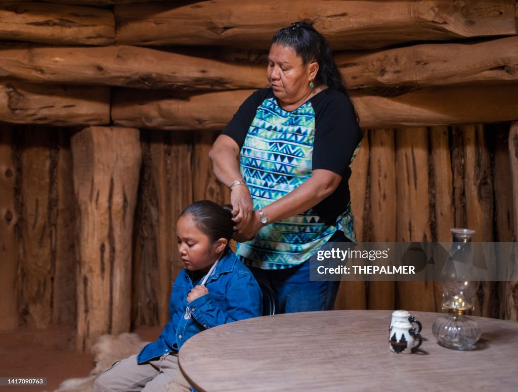 Navajo woman doing her son hair in the traditional way