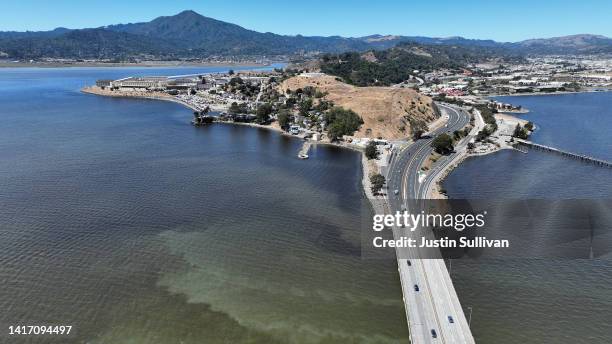 In an aerial view, cars drive on the Richmond-San Rafael Bridge over brownish water from an algal bloom in the San Francisco Bay on August 22, 2022...