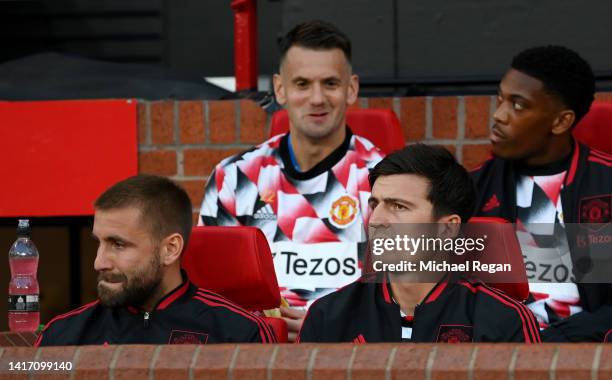 Harry Maguire and Luke Shaw of Manchester United look on from the substitutes bench prior to the Premier League match between Manchester United and...