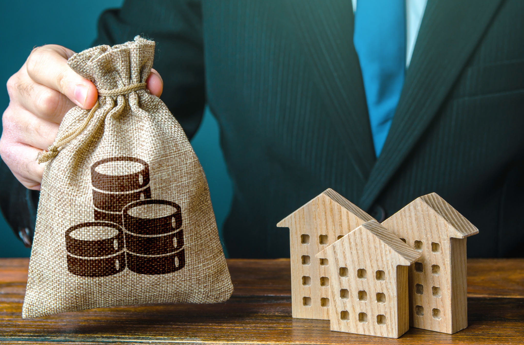 Sac d’argent dans une main et chiffres de bâtiments résidentiels. Investissements dans l’immobilier et la construction. Offre bancaire de prêt hypothécaire. Entreprise de location. Vente de logements. Acheter. Budget municipal. Impôts Sac d’argent dans une main et chiffres de bâtiments résidentiels. Investissements dans l’immobilier et la construction. Offre bancaire de prêt hypothécaire. Entreprise de location. Vente de logements. Acheter. Budget municipal. Impôts