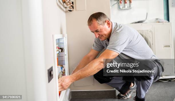 technician checking the pipes' diagnostics - water heater stockfoto's en -beelden