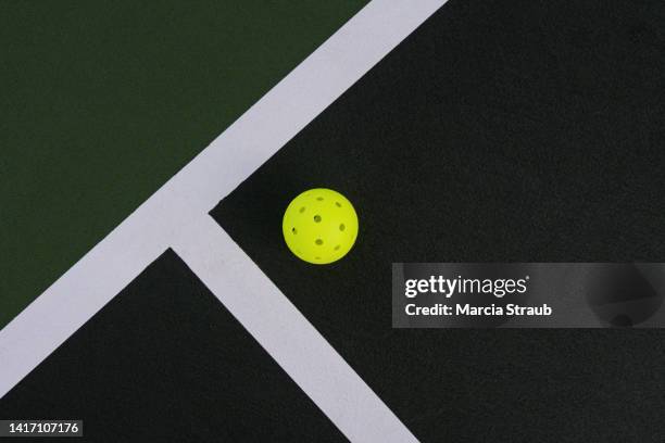 pickle ball on the white line of the court - paddle ball stock pictures, royalty-free photos & images