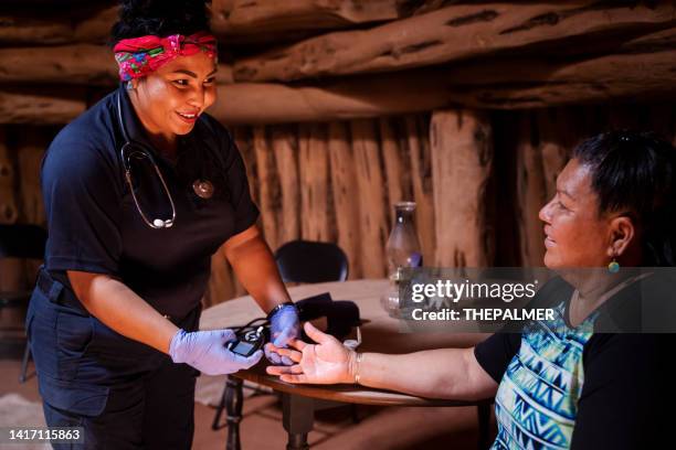 joven paramédica técnico en emergencias médicas ems revisando la glucosa en la sangre - ethnicity fotografías e imágenes de stock