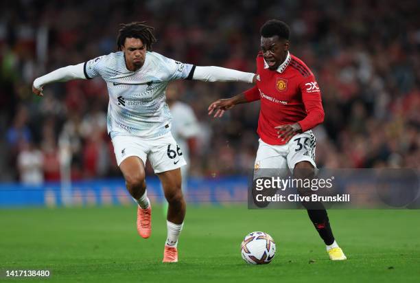 Anthony Elanga of Manchester United is challenged by Trent Alexander-Arnold of Liverpool during the Premier League match between Manchester United...