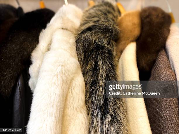 clothing rack of fur coats at antique flea market - fur coat stockfoto's en -beelden