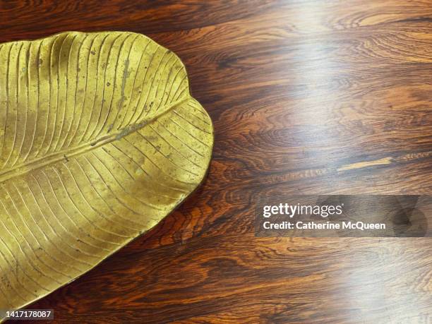 mid century modern coffee table & gold tray with leaf accent - bladnerf stockfoto's en -beelden