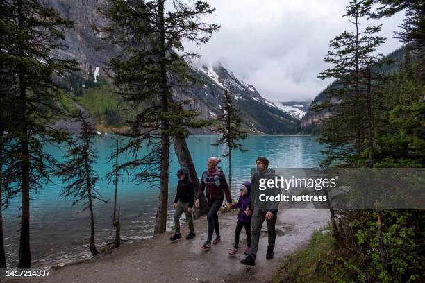 family hiking around a pristine glacial lake in winter - travel and canada and fall stockfoto's en -beelden