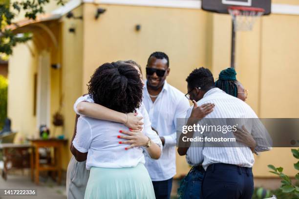 couple welcoming and embracing their friends that arrived to the dinner party - the party arrivals stock pictures, royalty-free photos & images