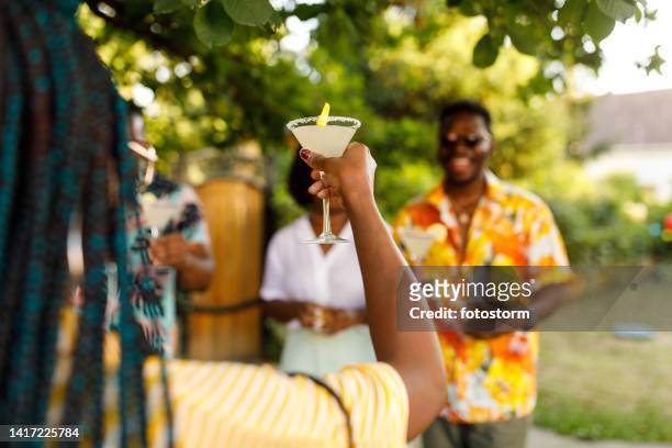 young woman raising her glass and proposing a toast during a summer garden party with friends - summer cocktails garden party drinks bildbanksfoton och bilder