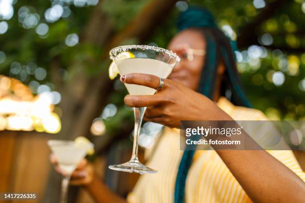selective focus shot of young woman holding martini glasses with margarita cocktail - cocktail party at home stock pictures, royalty-free photos & images