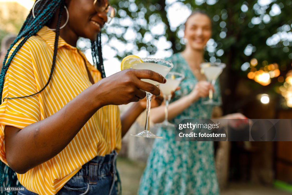 Two young women serving martini glasses with margarita cocktails