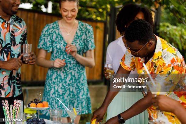 man making refreshing lemonade for his friends at the summer garden party - summer cocktails garden party drinks stockfoto's en -beelden