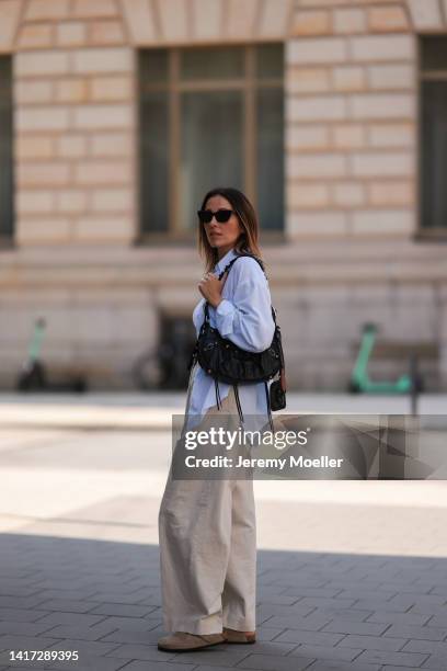 Elise Seitz seen wearing white tank top, black sunglasses, gold pearl necklace, a light blue SohoStudios shirt, black leather gold Celine Triomphe...