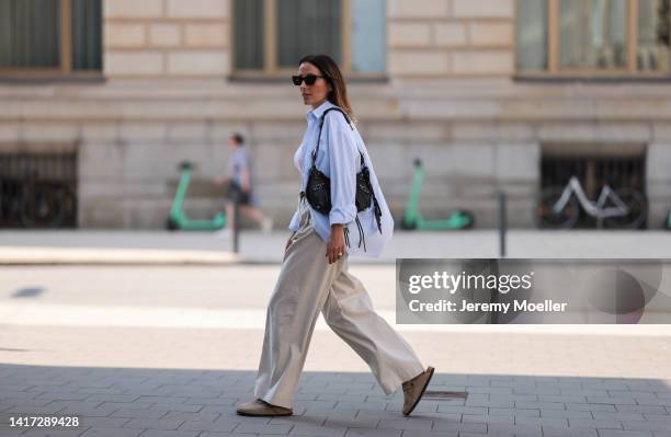 Elise Seitz seen wearing white tank top, black sunglasses, gold pearl necklace, a light blue SohoStudios shirt, black leather gold Celine Triomphe...