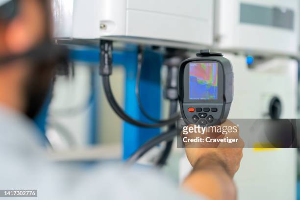 the electrical engineer used a thermal temperature indicator to examine hot spots on the balance phase of the wire system and equipment in the solar energy control room.
thermometer monitoring for solar inverter modules in variation temperature. - thermal imaging imagens e fotografias de stock