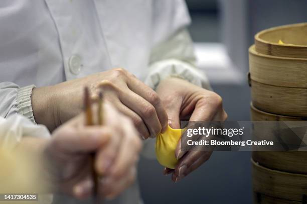 a chef cooks fresh chinese dumplings in a kitchen - dim sum meal stock pictures, royalty-free photos & images