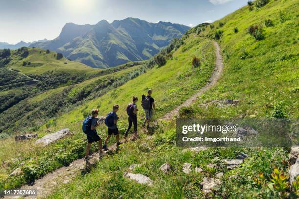 father and teenage kids hiking in the high mountains of austria (alps, vorarlberg) - oostenrijk stockfoto's en -beelden